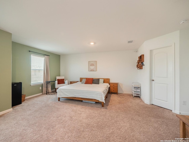 bedroom featuring visible vents, light colored carpet, and baseboards