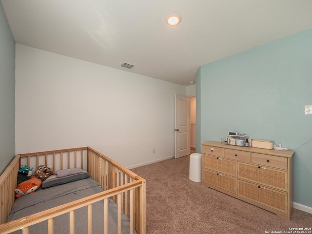 bedroom featuring visible vents, light colored carpet, and baseboards