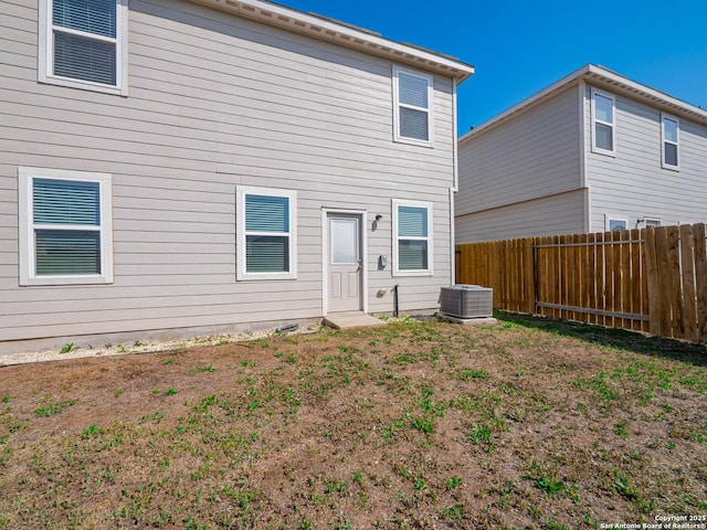 back of property with central air condition unit and fence