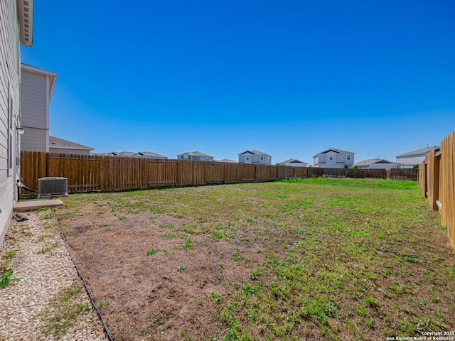 view of yard featuring central AC unit and a fenced backyard
