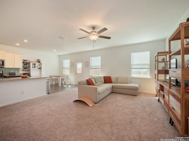 living area featuring visible vents, baseboards, ceiling fan, recessed lighting, and light carpet