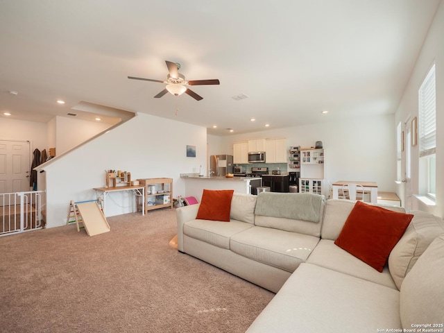 living area with recessed lighting, light colored carpet, and ceiling fan