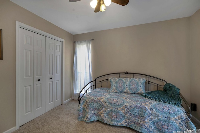 carpeted bedroom with a closet, baseboards, and ceiling fan