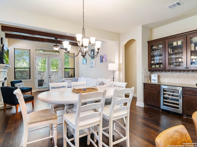 dining space featuring a chandelier, dark wood finished floors, visible vents, and wine cooler