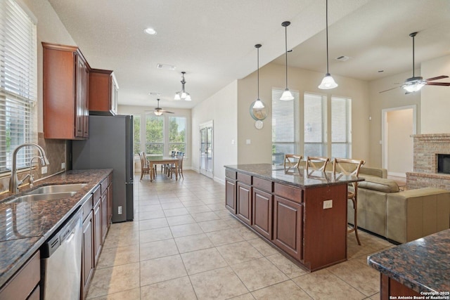 kitchen with stainless steel appliances, open floor plan, a sink, and ceiling fan