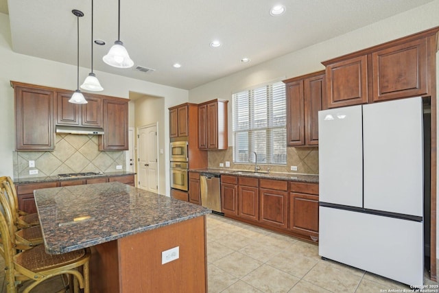 kitchen with a kitchen breakfast bar, tasteful backsplash, recessed lighting, a sink, and stainless steel appliances