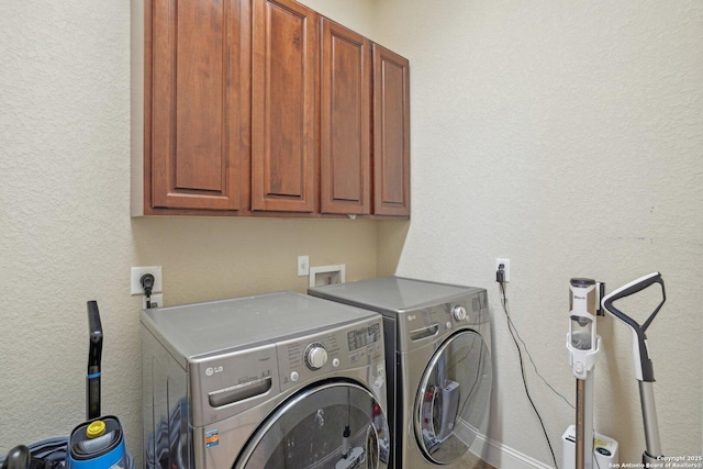 washroom featuring independent washer and dryer, baseboards, and cabinet space