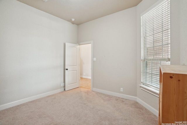 carpeted empty room with baseboards and a healthy amount of sunlight