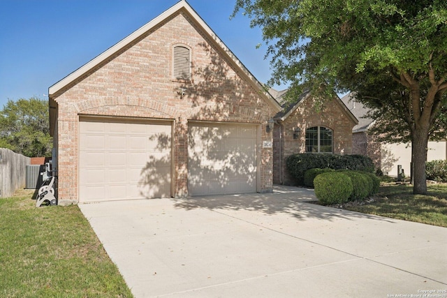 view of front of house with driveway, a garage, fence, and brick siding