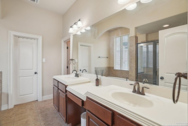 bathroom with a sink, tile patterned floors, double vanity, and a stall shower