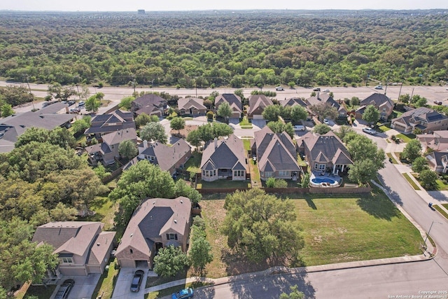 aerial view featuring a wooded view and a residential view