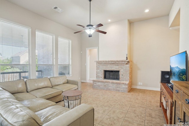 living room with ceiling fan, a fireplace, light tile patterned floors, visible vents, and baseboards