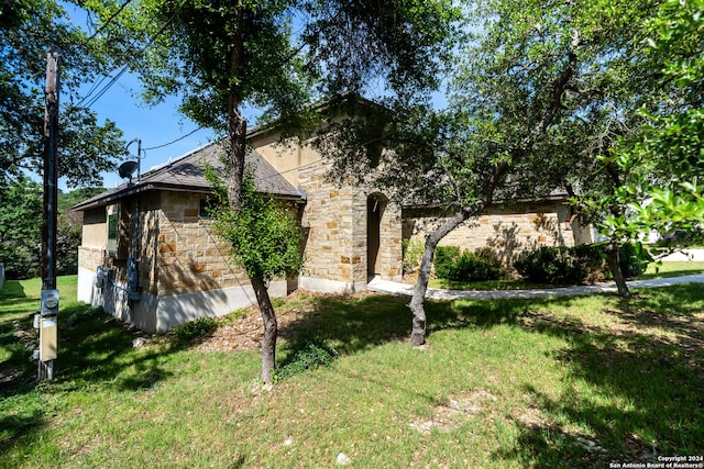view of front of home with stone siding and a front lawn