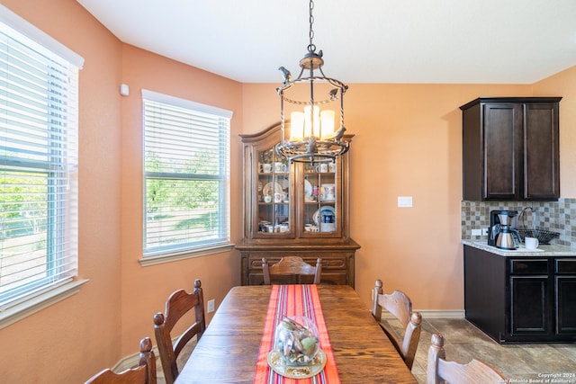 dining space featuring baseboards and an inviting chandelier