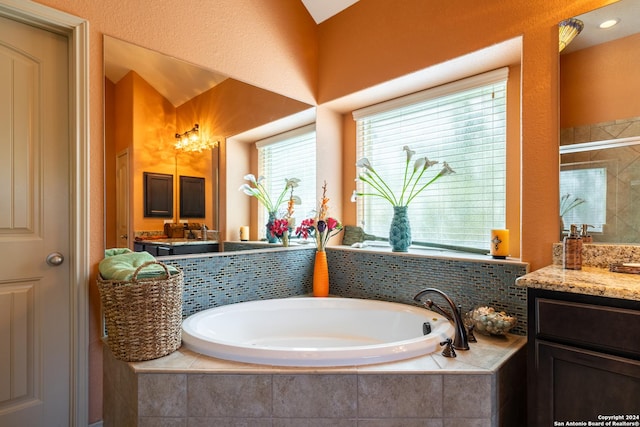 bathroom featuring vanity, a bath, and a stall shower