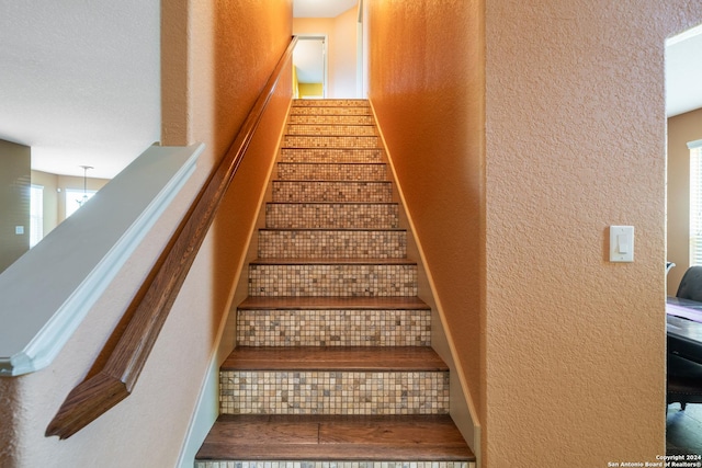stairs featuring a textured wall