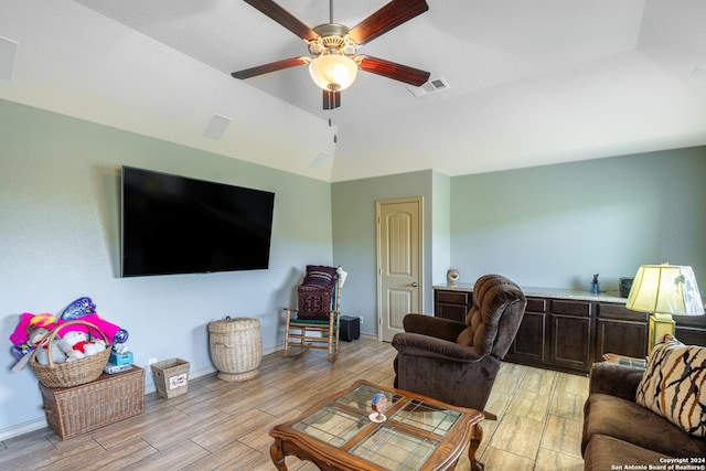 living room with baseboards, vaulted ceiling, a ceiling fan, visible vents, and wood tiled floor