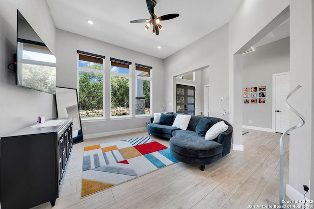 living area featuring recessed lighting, light wood-style floors, baseboards, and ceiling fan
