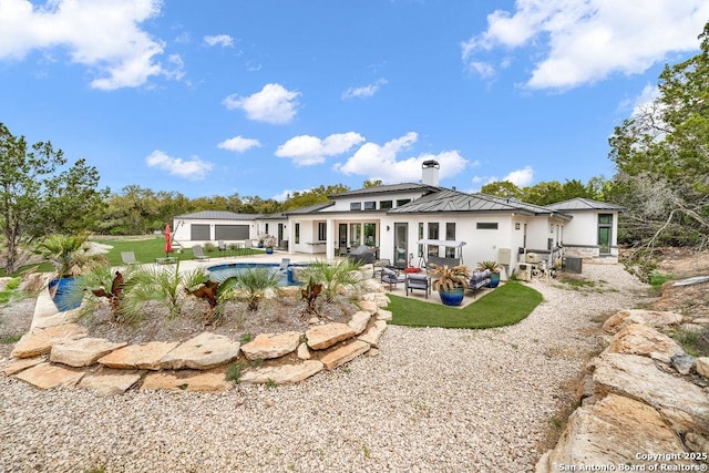 back of house with an outdoor pool, a chimney, and a patio area