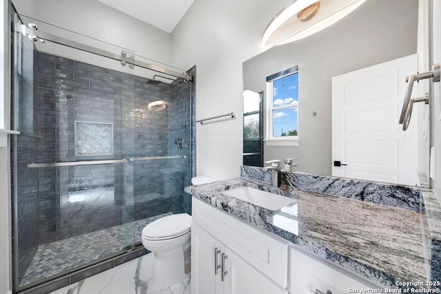 bathroom with toilet, vanity, marble finish floor, and a stall shower
