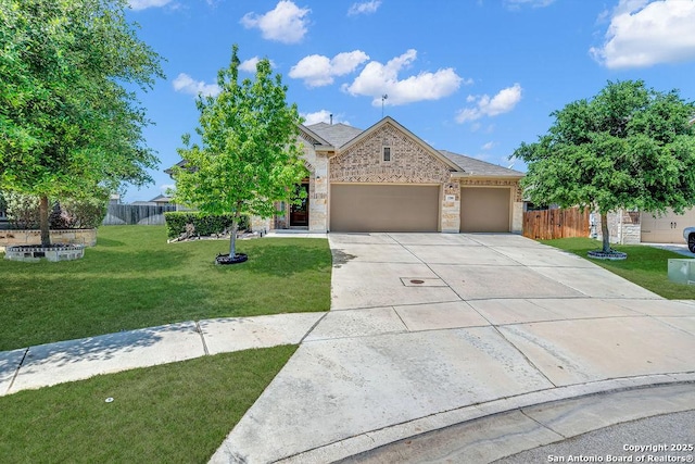 view of front of home with driveway, stone siding, an attached garage, a front lawn, and fence