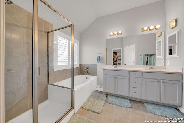 bathroom featuring a shower stall, a bath, tile patterned flooring, and vaulted ceiling