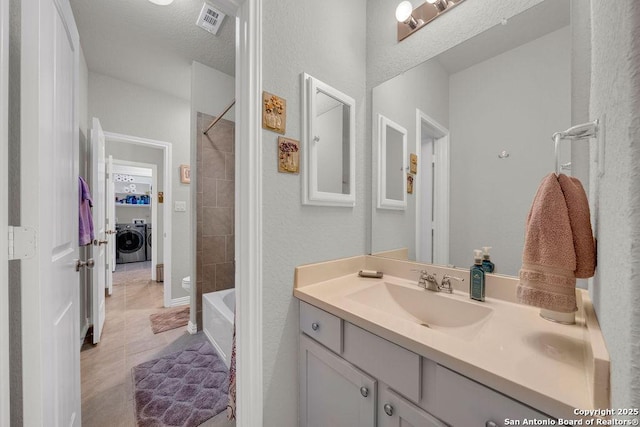 bathroom with visible vents, shower / washtub combination, vanity, washer / dryer, and tile patterned flooring