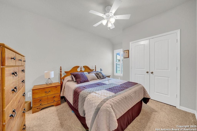 bedroom featuring a closet, baseboards, ceiling fan, vaulted ceiling, and light carpet