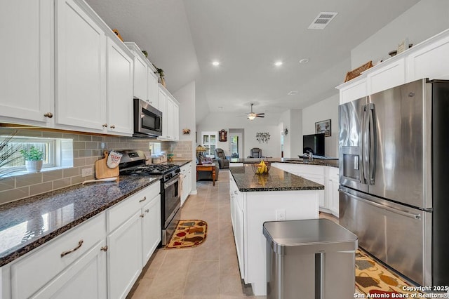 kitchen featuring tasteful backsplash, visible vents, white cabinets, vaulted ceiling, and stainless steel appliances