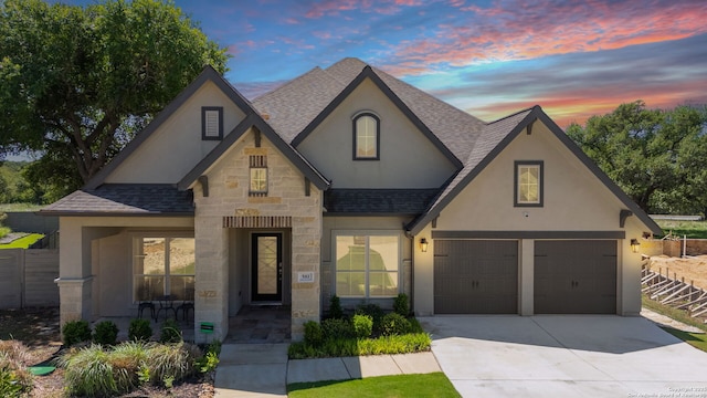 581 Vale Ct, New Braunfels, TX 78132 - view of front facade with roof with shingles, stucco siding, driveway, stone siding, and a garage