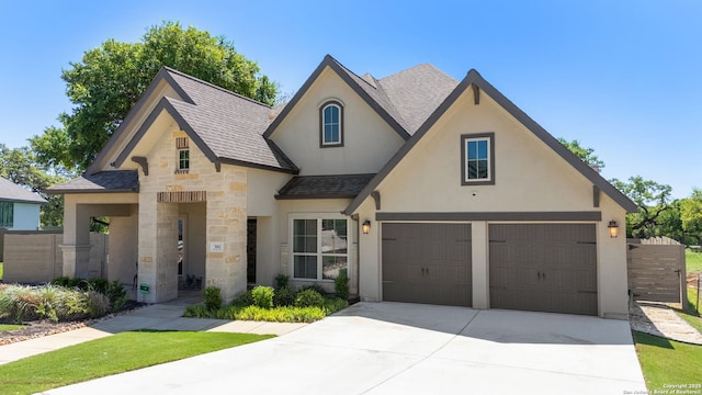 581 Vale Ct, New Braunfels, TX 78132 - view of front of house with roof with shingles, stucco siding, driveway, stone siding, and an attached garage