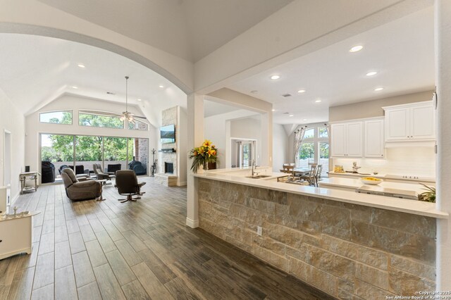 581 Vale Ct, New Braunfels, TX 78132 - kitchen with recessed lighting, open floor plan, white cabinets, lofted ceiling, and arched walkways