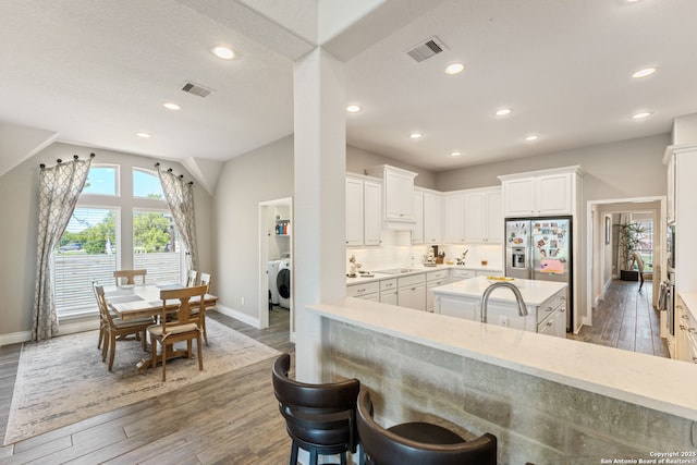 581 Vale Ct, New Braunfels, TX 78132 - kitchen with visible vents, baseboards, washer / clothes dryer, stainless steel fridge, and dark wood-type flooring
