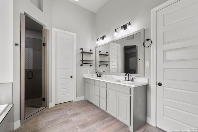 291 Strasbourg, Castroville, TX 78009 - full bath featuring a shower stall, double vanity, wood finished floors, and baseboards