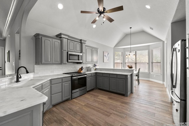 291 Strasbourg, Castroville, TX 78009 - kitchen with gray cabinetry, stainless steel appliances, a peninsula, a sink, and lofted ceiling