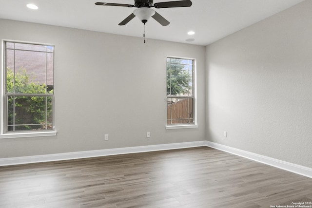 empty room with wood finished floors, ceiling fan, and recessed lighting