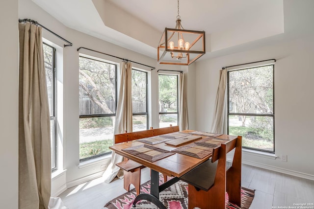 dining room with a chandelier, a wealth of natural light, and baseboards