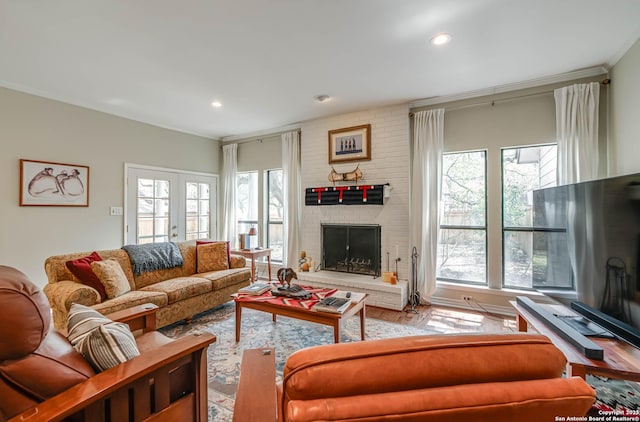living area featuring wood finished floors, recessed lighting, a brick fireplace, and a wealth of natural light