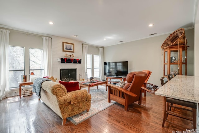 living room with visible vents, recessed lighting, wood finished floors, and a fireplace