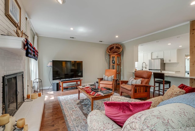 living area with light wood-style flooring, a fireplace, baseboards, and recessed lighting
