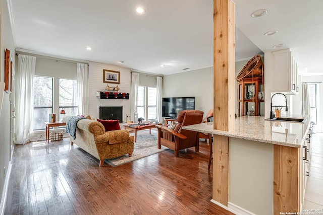 living area with wood-type flooring, recessed lighting, plenty of natural light, and a fireplace