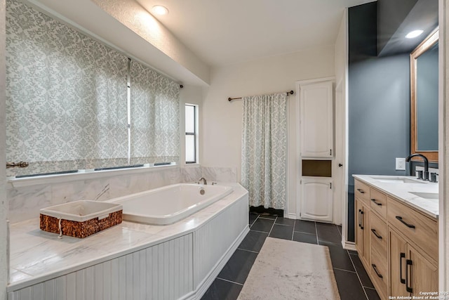 full bath featuring tile patterned flooring, double vanity, a garden tub, and a sink