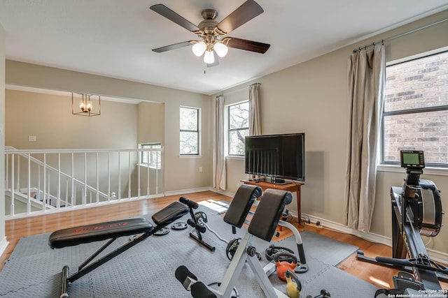 exercise area featuring wood finished floors, ceiling fan, and baseboards