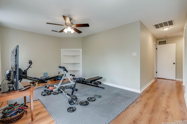 workout room with visible vents, ceiling fan, and light wood-style floors