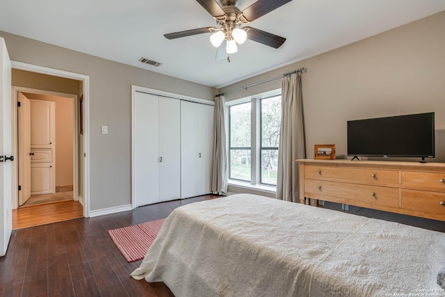 bedroom featuring a closet, a ceiling fan, visible vents, wood finished floors, and baseboards
