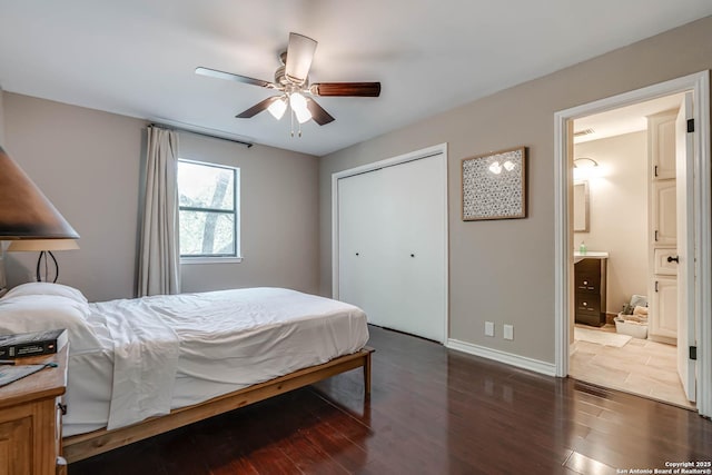 bedroom with a closet, baseboards, ensuite bathroom, ceiling fan, and wood finished floors