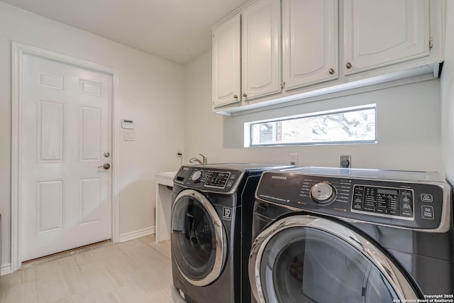 laundry area featuring separate washer and dryer, baseboards, and cabinet space