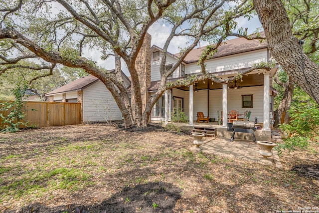 back of property featuring a patio and fence