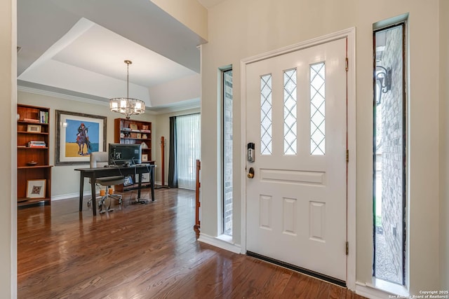 entryway with a tray ceiling, baseboards, an inviting chandelier, and wood finished floors