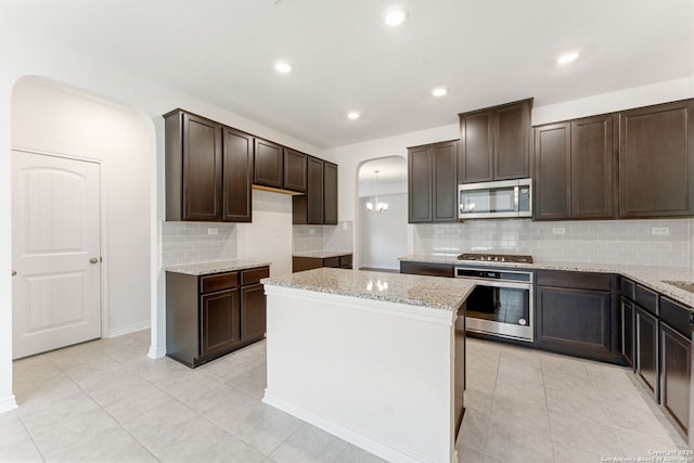 29991 Jove, Bulverde, TX 78163 - kitchen featuring light stone countertops, arched walkways, dark brown cabinetry, and stainless steel appliances